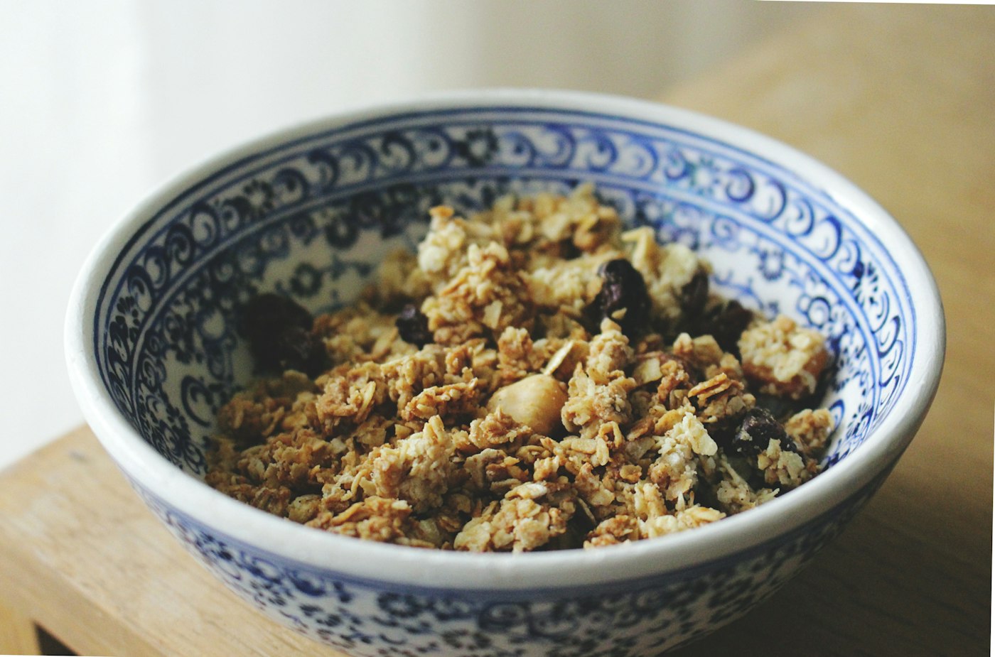 A blue patterned bowl filled with apple and oat crumble